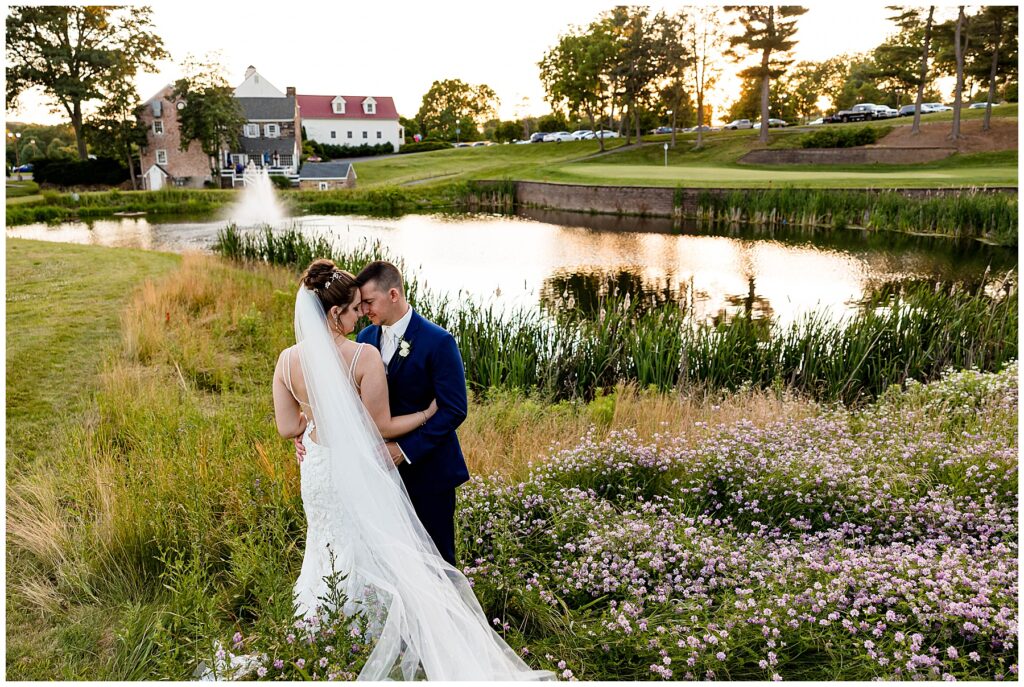 Wedding couple embraces on hills of Chester County golf course wedding