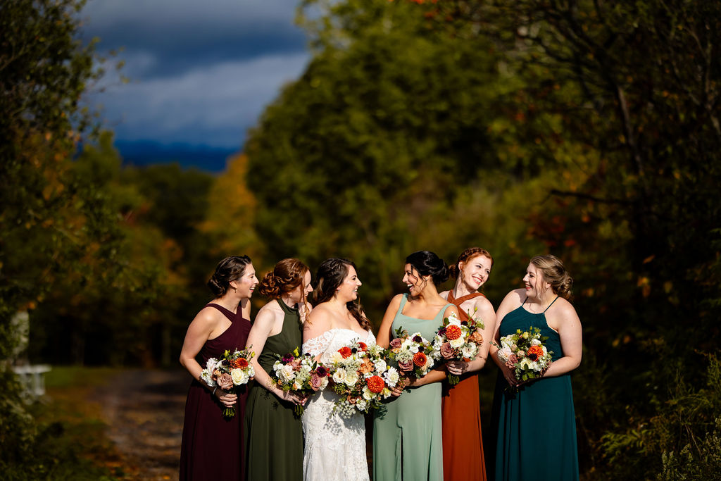 Bride and her bridesmaids laugh. 