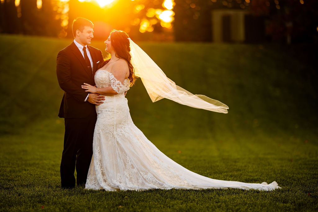 A bride and groom stand on the lawn of Blue Mountain Resort Pa for their wedding.
