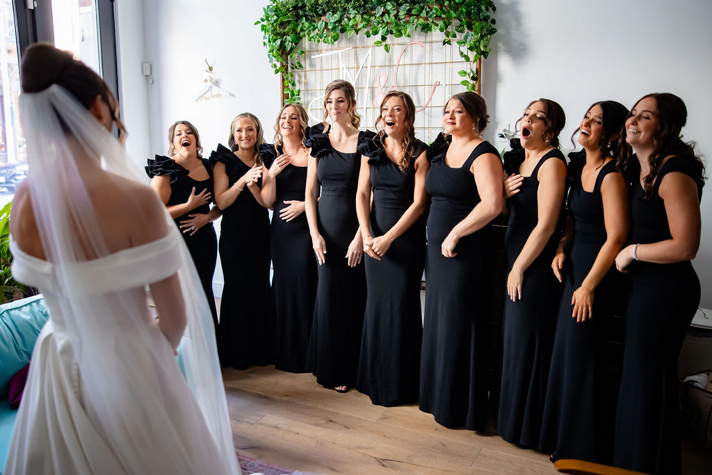 A bride has her first look with her bridesmaids. 
