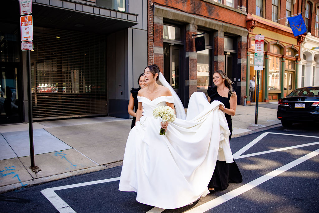 Bridesmaids hold a brides dress in Philadelphia. 